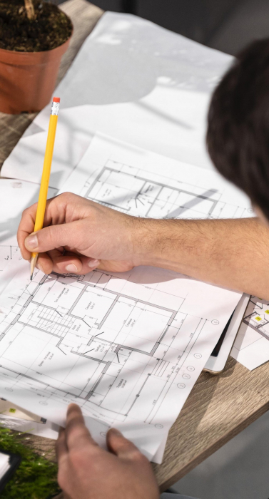 high-angle-man-working-eco-friendly-wind-power-project-with-papers-pencil